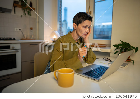 Concentrated stressed senior businesswoman works on remote at home, finishes deadline at late hours. Concentrated stressed senior businesswoman works on remote at home, finishes deadline at late hours. 136041979