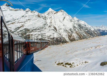 戈爾內格拉特鐵路列車行駛在瑞士瓦萊州採爾馬特白雪皚皚的山脈之中。 136042062