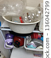 Disorganized kitchen drawers and cluttered storage containers 136042799