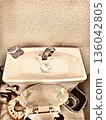 A view of the washbasin and sink area in a toilet, giving it a sense of everyday life. 136042805