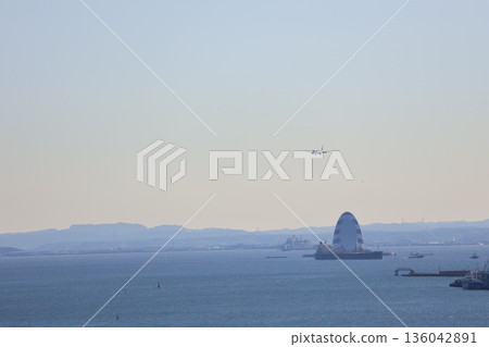 A view of the blue sky, a flying aircraft, hazy mountains, cityscapes, the blue waters of Tokyo Bay, ships, and the Wind Tower. A view of the blue sky, a flying aircraft, hazy mountains, cityscapes, the blue waters of Tokyo Bay, ships, and the Wind Tower. 136042891