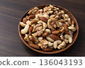 Mixed nuts in a wooden bowl Mixed nuts in a wooden bowl 136043193