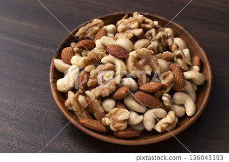 Mixed nuts in a wooden bowl 136043193