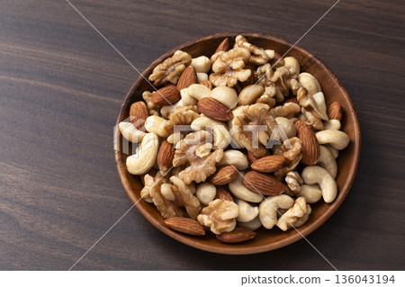 Mixed nuts in a wooden bowl Mixed nuts in a wooden bowl 136043194