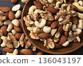Mixed nuts in a wooden bowl Mixed nuts in a wooden bowl 136043197
