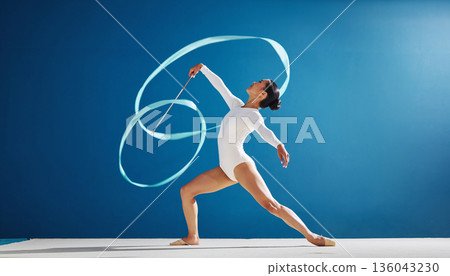 一位女子藝術體操運動員正在揮舞彩帶。藍天白雲，白色體操服，畫面清新怡人。 136043230