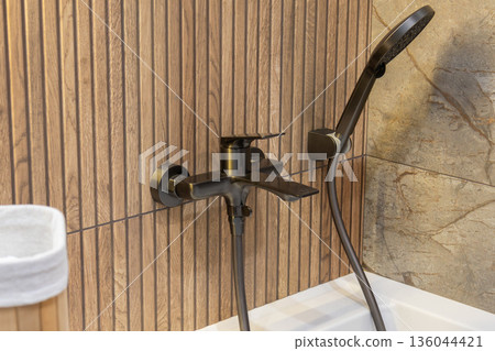 water faucet and showerhead are connected to the wall in a simple bathroom design using wood and stone tiles water faucet and showerhead are connected to the wall in a simple bathroom design using wood and stone tiles 136044421