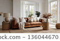 Scandinavian style living room with sofa, pillows, blanket. Center of living room features comfortable couch with several soft stylish cushions. Modern interior design, cozy home atmosphere. 136044670