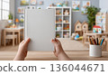 Childhood education reading concept mockup image neutral background. Little Child's hands hold open book with blank pages in nursery room. 136044671