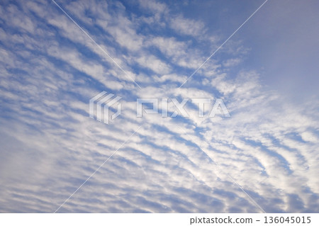 Clear blue sky with wispy clouds over a calm, expansive atmosphere 136045015