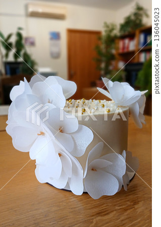 White cake with paper orchid decorations for celebration or wedding, elegant dessert centerpiece 136045023