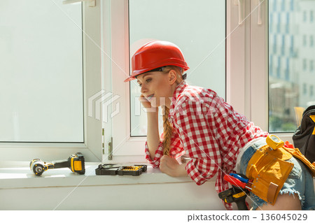 Woman with helmet next to the window Woman with helmet next to the window 136045029