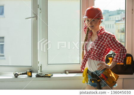 Woman with helmet next to the window Woman with helmet next to the window 136045030