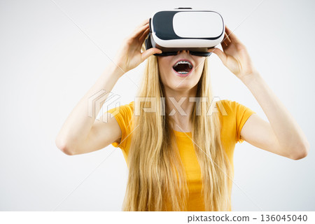 Girl wearing virtual reality goggles. 136045040