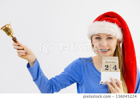 Christmas woman holding calendar and bell Christmas woman holding calendar and bell 136045224