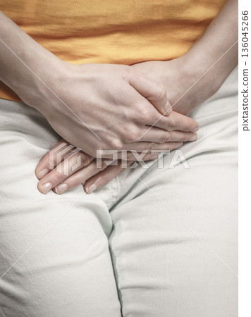 Woman with hands holding her crotch Woman with hands holding her crotch 136045266