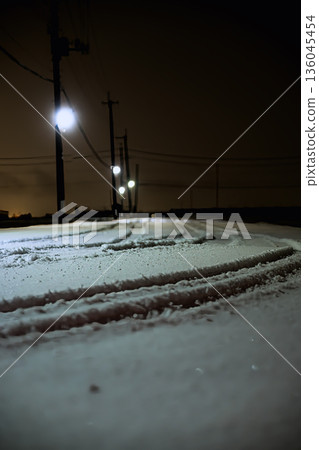 Winter road: Endless road and street lights in the snowy landscape 136045454