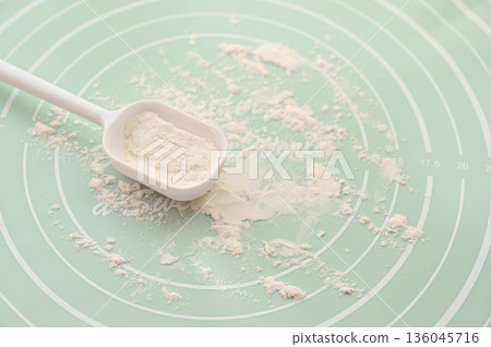 Sprinkle flour on a cooking mat 136045716