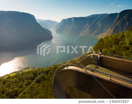 Tourist enjoying fjord view on Stegastein viewpoint Norway Tourist enjoying fjord view on Stegastein viewpoint Norway 136045897