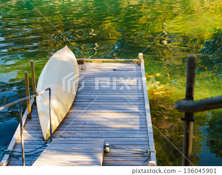 Old wooden pier with boat on lake Old wooden pier with boat on lake 136045901