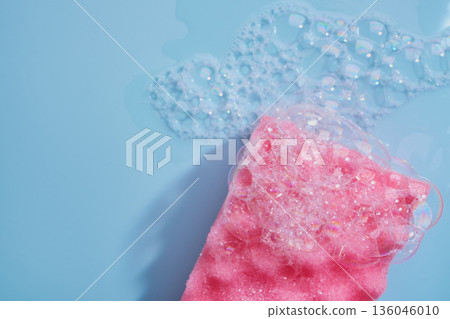 Pink sponge with foam and suds creating clean and fresh background Pink sponge with foam and suds creating clean and fresh background 136046010