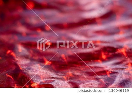 Vibrant red satin fabric with soft light, glossy folds, and rich texture for dramatic photography 136046119