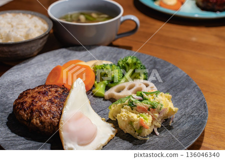 Hamburg steak and side dish on a wooden table Dinner with rice and soup Hamburg steak and side dish on a wooden table Dinner with rice and soup 136046340