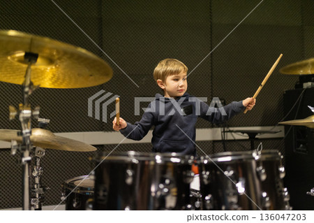 Young musician practicing drums developing musical talent Young musician practicing drums developing musical talent 136047203