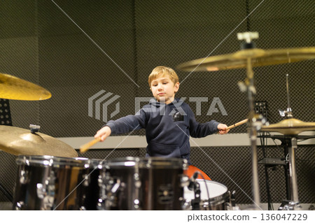 Young boy learning playing drums musical instrument 136047229