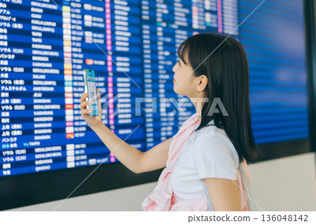 一名女子正在機場查看電子顯示器（照片由關西國際機場（KIX）提供） 136048142