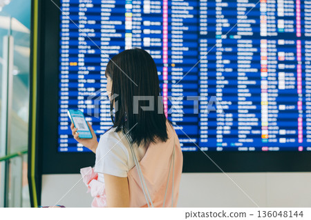 A woman checking the electronic display board at the airport (Photo courtesy of Kansai International Airport (KIX)) A woman checking the electronic display board at the airport (Photo courtesy of Kansai International Airport (KIX)) 136048144