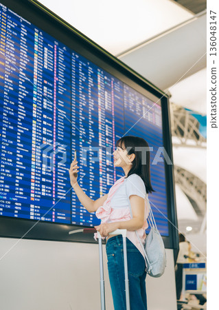 一名女子正在機場觀看電子顯示器(照片由關西國際機場(KIX)提供) 一名女子正在機場觀看電子顯示器(照片由關西國際機場(KIX)提供) 136048147
