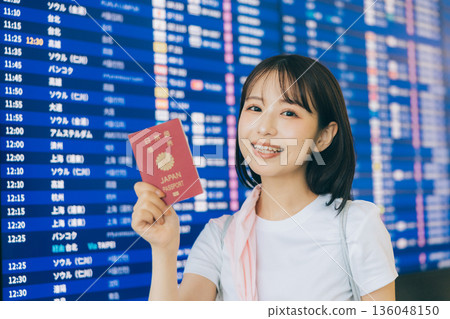 A woman holding a passport at the airport (Photo courtesy of Kansai International Airport (KIX)) 136048150