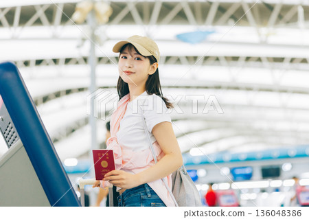 A woman checking in by herself at the airport (Photo courtesy of Kansai International Airport (KIX)) A woman checking in by herself at the airport (Photo courtesy of Kansai International Airport (KIX)) 136048386