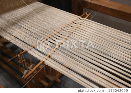 Fabric being woven on a loom Fabric being woven on a loom 136048639