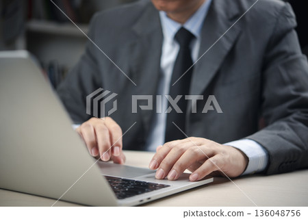 Close-up of male executive hands using laptop touchpad at office desk, professional manager in formal wear analyzing data, sending emails, or managing tasks for business success and productivity. Close-up of male executive hands using laptop touchpad at office desk, professional manager in formal wear analyzing data, sending emails, or managing tasks for business success and productivity. 136048756
