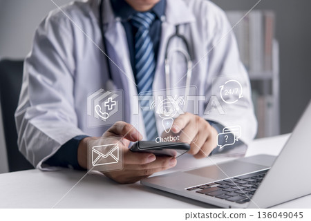 Healthcare, Chatbot. A doctor uses a smartphone beside a laptop with medical contact icons to access. AI chatbot for 24/7 assistance, telemedicine, patient support, and digital health concept. Healthcare, Chatbot. A doctor uses a smartphone beside a laptop with medical contact icons to access. AI chatbot for 24/7 assistance, telemedicine, patient support, and digital health concept. 136049045