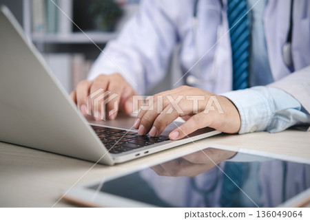 Medical doctor working on laptop in hospital patient records and communicate via telehealth, technology medicine, data security, and modern care. concept telehealth productivity Medical doctor working on laptop in hospital patient records and communicate via telehealth, technology medicine, data security, and modern care. concept telehealth productivity 136049064