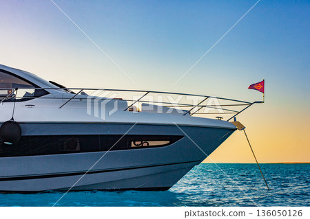 A large white boat with a red flag on the bow 136050126