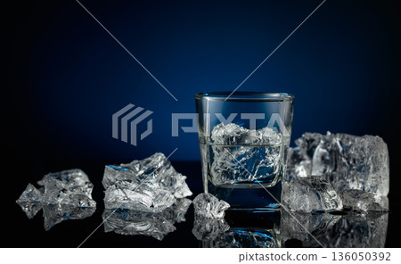Crystal clear vodka or gin in a glass with ice. Crystal clear vodka or gin in a glass with ice. 136050392