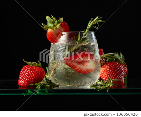 Cocktail gin tonic with ice, strawberries, and rosemary. Cocktail gin tonic with ice, strawberries, and rosemary. 136050420