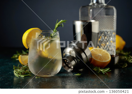 Cocktail gin tonic with natural ice, lemon, and rosemary. Cocktail gin tonic with natural ice, lemon, and rosemary. 136050421