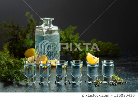 Gin with juniper berries and lemon slices. Gin with juniper berries and lemon slices. 136050436