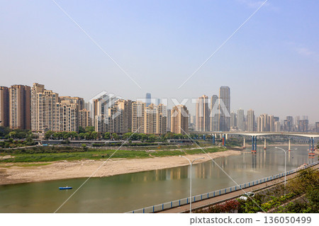 Chongqing China 4.7.2025. A city with a river running through it and a bridge over it Chongqing China 4.7.2025. A city with a river running through it and a bridge over it 136050499