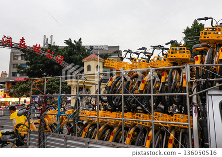 A large stack of bicycles are piled up in front of a building A large stack of bicycles are piled up in front of a building 136050516