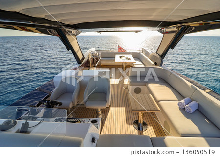 A boat with a white canopy and a blue sky in the background 136050519