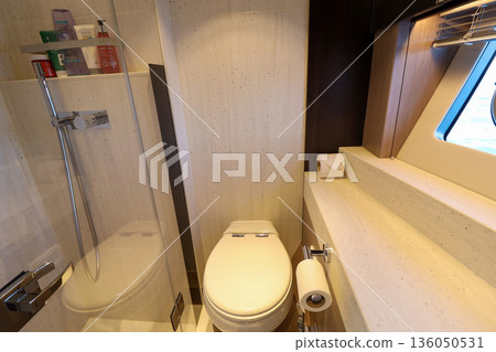 A small bathroom with a toilet and a shower in luxury boat A small bathroom with a toilet and a shower in luxury boat 136050531