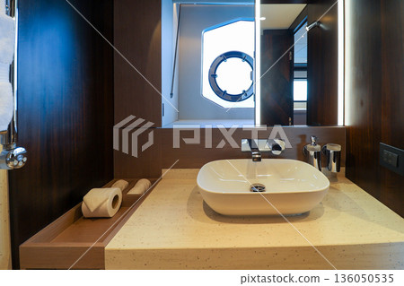 A bathroom with a white sink and a mirror in luxury boat A bathroom with a white sink and a mirror in luxury boat 136050535