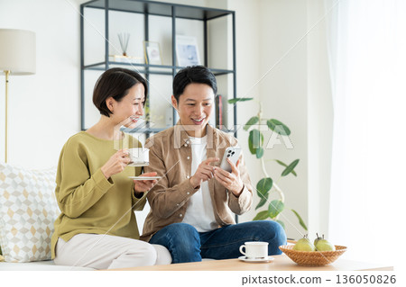 A middle-aged couple relaxing in the living room A middle-aged couple relaxing in the living room 136050826