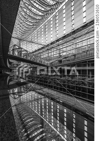 A modern architectural space with a symmetrical structure created by reflections 136051610